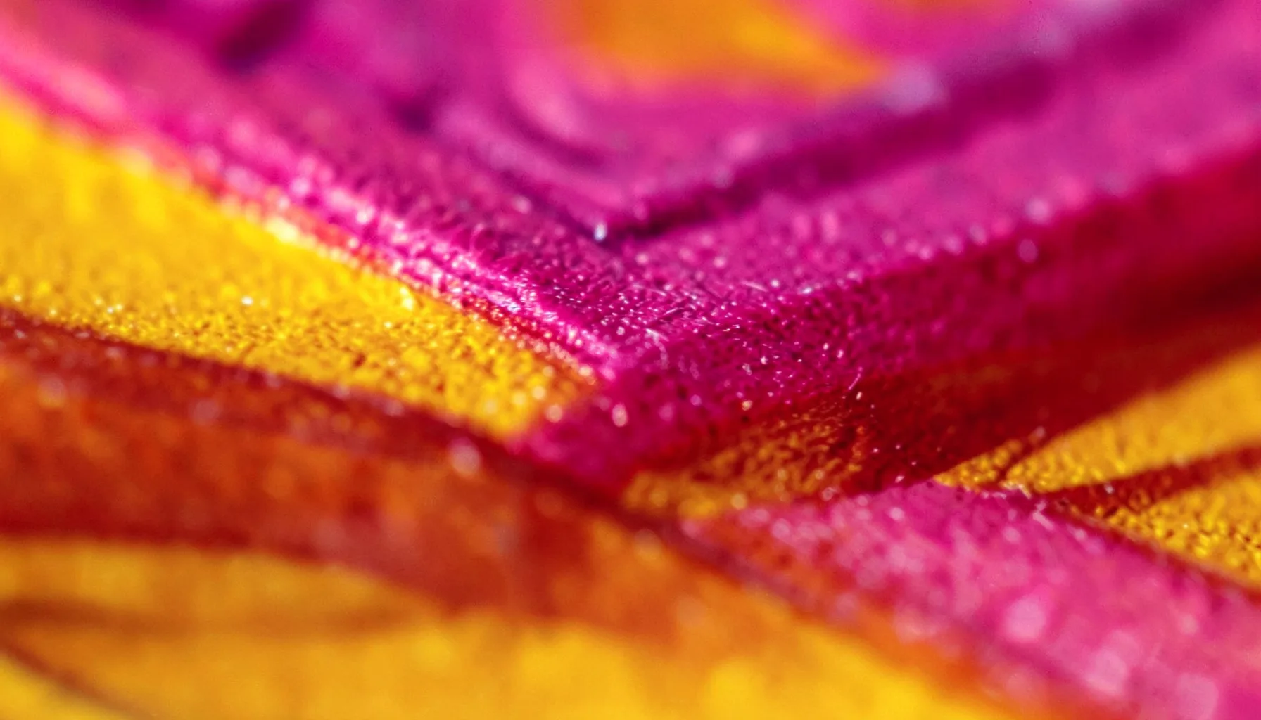 Extreme close-up of a polished magenta and amber casino chip edge with deep shadow grooves